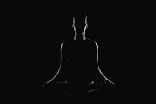 A person seated in a calm breathing practice, eyes closed, quiet and still